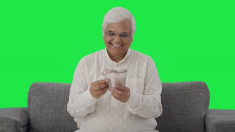 Happy-Indian-old-man-counting-money-Green-screen