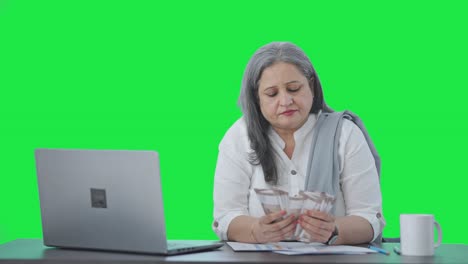 Indian-senior-businesswoman-counting-money-Green-screen