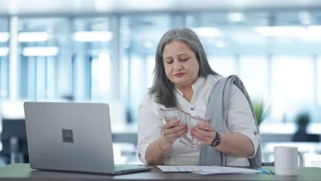 Happy-Indian-senior-businesswoman-counting-money