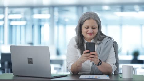 Happy-Indian-senior-female-manager-chatting-on-phone