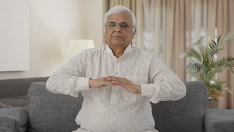 Relaxed-Indian-old-man-doing-breathe-in-breathe-out-exercise