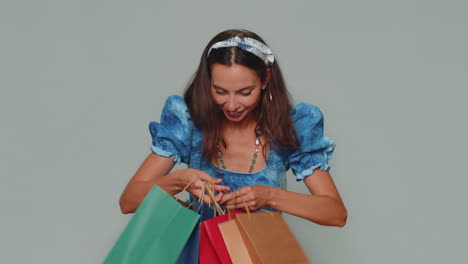 Feliz-Y-Sonriente-Joven-Mostrando-Bolsas-De-Compras,-Descuentos-Publicitarios,-Sorprendida-Con-Precios-Bajos