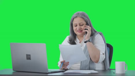 Happy-Indian-senior-female-manager-talking-on-phone-Green-screen