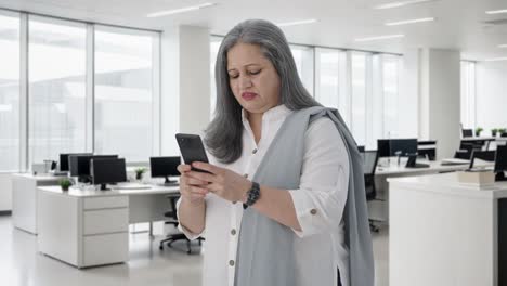 Angry-Indian-senior-businesswoman-chatting-on-phone