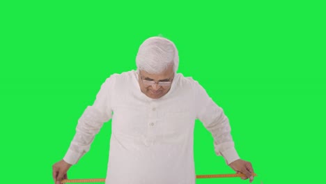 Happy-Indian-old-man-measuring-waist-using-inch-tape-Green-screen