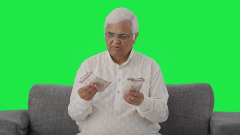 Sad-Indian-old-man-counting-money-Green-screen