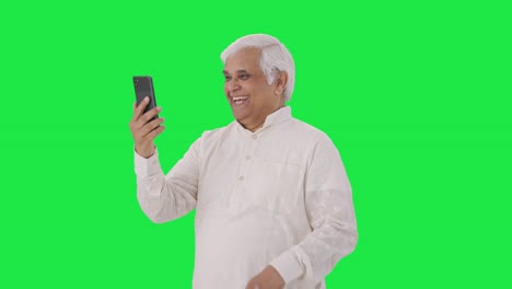 Happy-Indian-old-man-talking-on-video-call-Green-screen