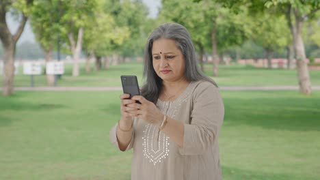 Indian-old-woman-chatting-on-phone-in-park