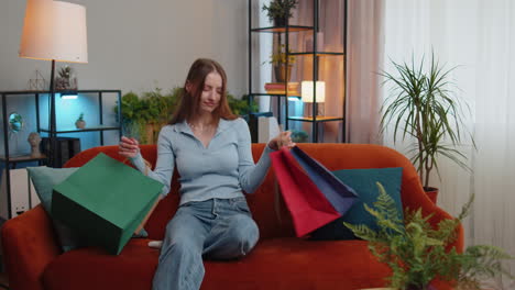 Happy-young-woman-shopaholic-consumer-came-back-home-after-online-shopping-sale-with-bags-at-home