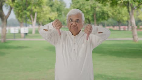 Indian-old-man-showing-thumbs-down-in-park