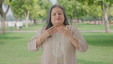 Indian-old-woman-doing-breathe-in-breathe-out-exercise-in-park