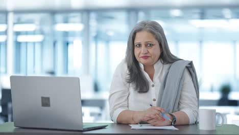 Serious-Indian-senior-businesswoman-talking-to-someone