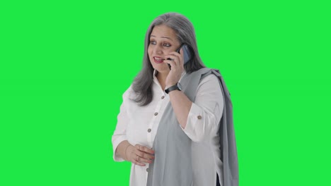 Happy-Indian-senior-businesswoman-talking-on-call-Green-screen