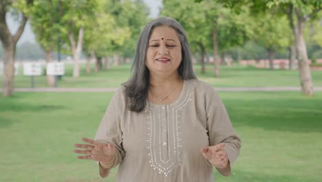 Happy-Indian-old-woman-talking-to-the-camera-in-park