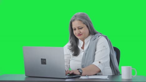 Happy-Indian-senior-female-manager-working-on-laptop-Green-screen