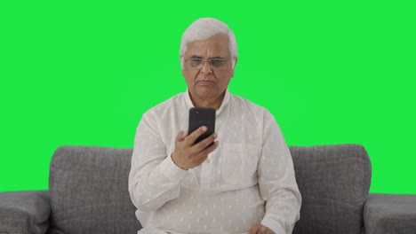 Indian-old-man-scrolling-phone-Green-screen