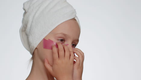 Smiling-child-girl-applying-pink-patches-under-eyes,-teenager-natural-skin-care,-perfect-fresh-clean