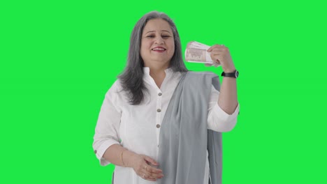 Happy-Indian-senior-businesswoman-using-money-as-fan-Green-screen