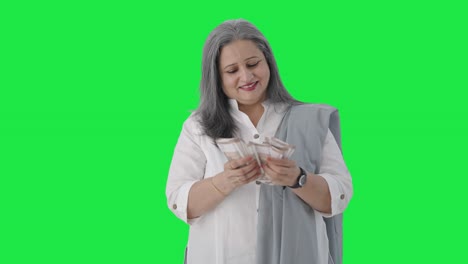 Happy-Indian-senior-businesswoman-counting-money-Green-screen