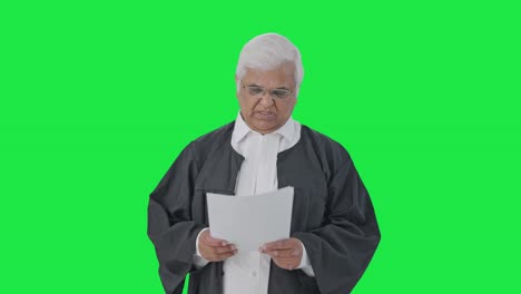 Frustrated-Indian-senior-lawyer-reading-court-case-papers-Green-screen