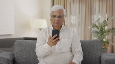 Indian-old-man-scrolling-phone