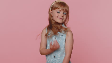 Cheerful-lovely-young-preteen-child-girl-kid-smiling,-looking-at-camera-on-studio-pink-background