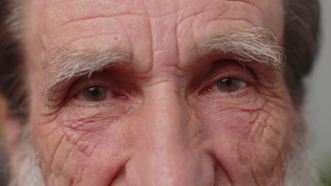 Extreme-close-up-macro-portrait-of-wrinkled-face,-old-senior-beautiful-man's-eyes-looking-at-camera