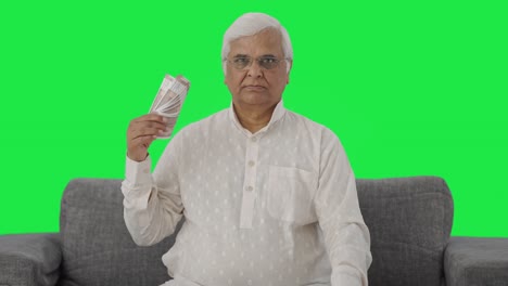 Confident-Indian-old-man-using-money-as-fan-Green-screen