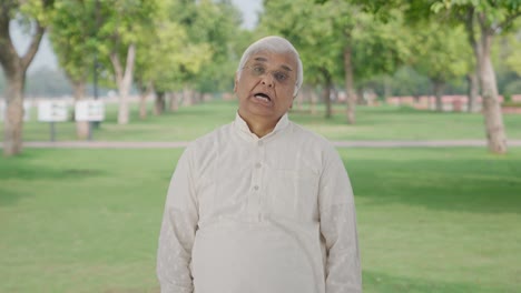 Sleepy-and-tired-Indian-old-man-yawning-in-park