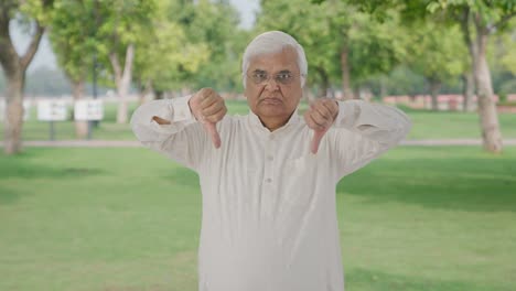 Angry-Indian-old-man-showing-thumbs-down-in-park