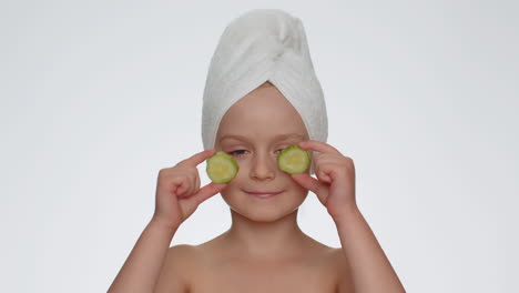 Smiling-child-girl-kid-holding-slices-of-cucumber,-covering-eyes,-natural-cosmetics,-face-skin-care