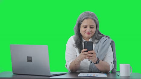 Happy-Indian-senior-female-manager-chatting-on-phone-Green-screen