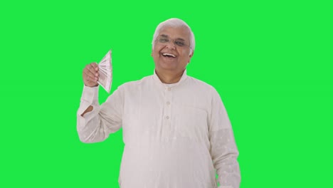 Happy-Indian-old-man-using-money-as-fan-Green-screen