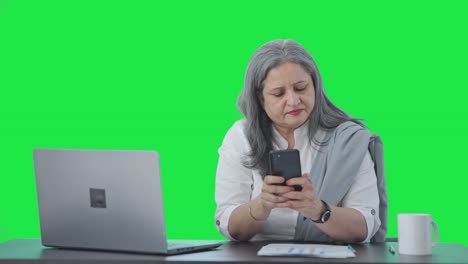 Indian-senior-female-manager-chatting-on-phone-Green-screen