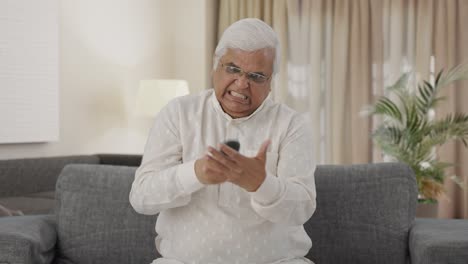 Angry-Indian-old-man-trying-to-fix-TV-remote