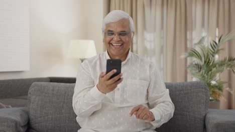 Happy-Indian-old-man-scrolling-phone