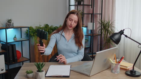 Young-business-woman-blogger-using-smartphone-shooting-video-call-for-social-media-at-home-office