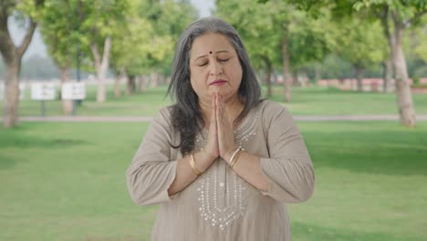 Religious-Indian-old-woman-praying-to-God-in-park