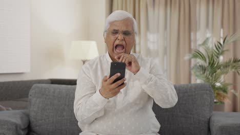 Sleepy-Indian-old-man-scrolling-phone