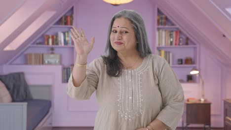 Happy-and-cheerful-Indian-old-woman-waving-and-saying-hello