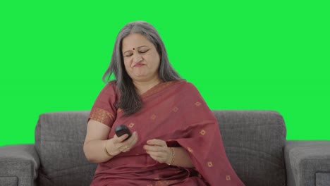 Angry-Indian-old-woman-trying-to-fix-TV-remote-Green-screen