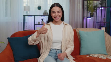 Happy-young-woman-looking-approvingly-at-camera-showing-thumbs-up,-like-positive-sign,-good-news