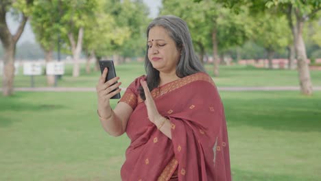 Indian-old-woman-talking-on-video-call-in-park