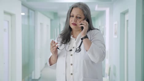 Indian-senior-female-doctor-talking-on-call