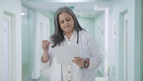 Indian-senior-female-doctor-explaining-reports-to-patient