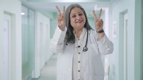 Feliz-Doctora-India-Senior-Mostrando-El-Signo-De-La-Victoria