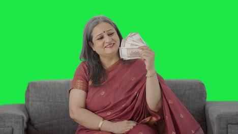 Happy-Indian-old-woman-using-money-as-fan-Green-screen