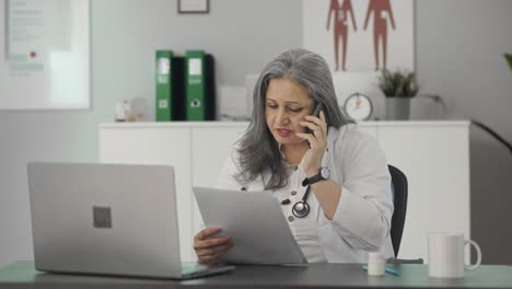 Indian-senior-female-doctor-consulting-patient-on-call