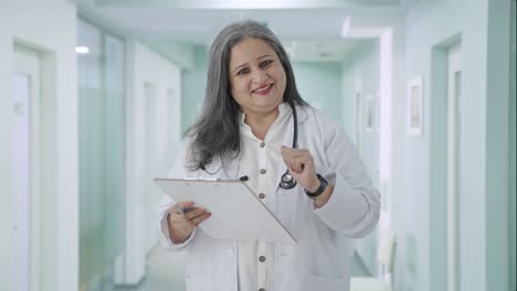 Happy-Indian-senior-female-doctor-talking-to-patient