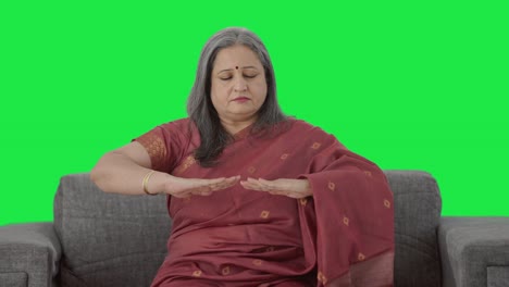 Relaxed-Indian-old-woman-doing-breathe-in-breathe-out-exercise-Green-screen